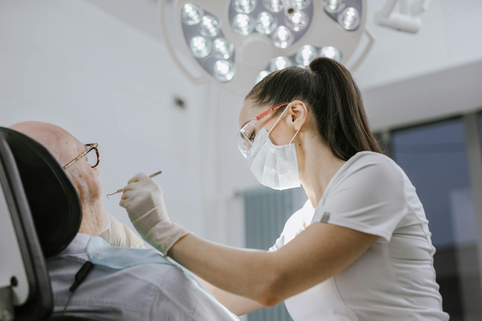 A dentist gently examining an older patient